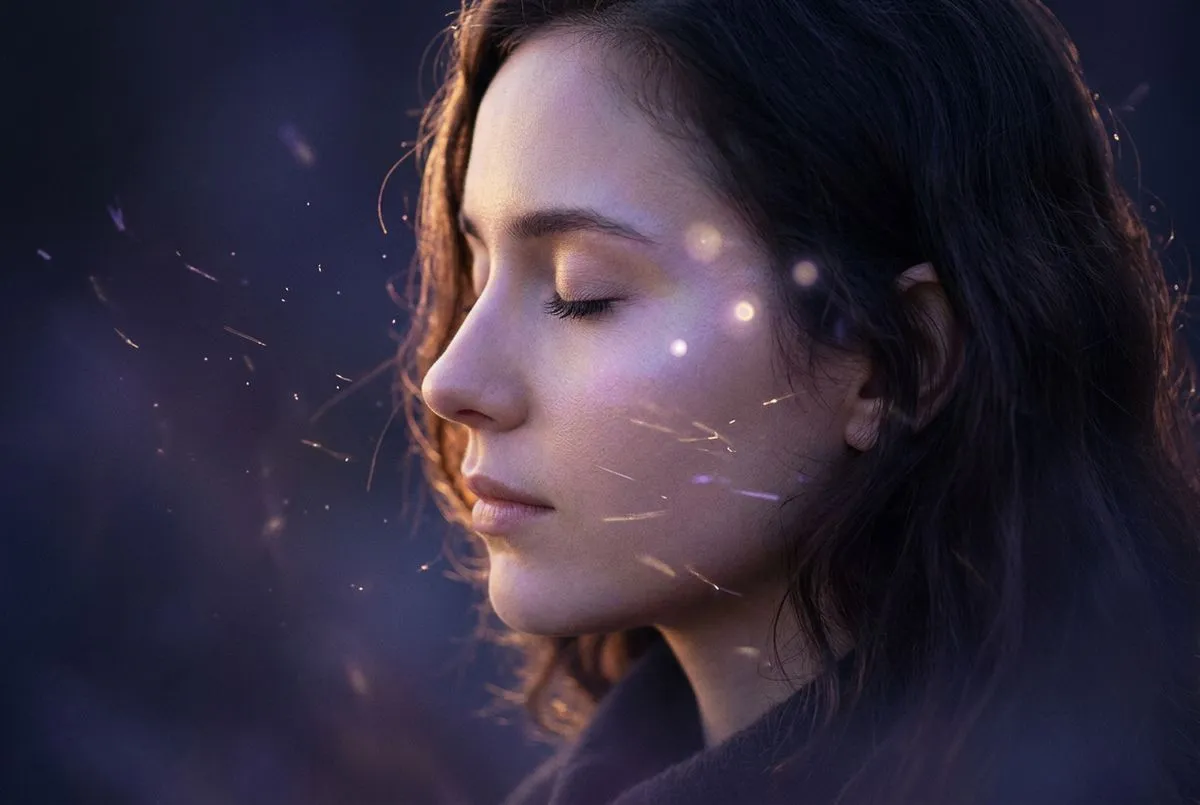 側面半身女子站在夜晚森林邊緣，周圍環繞著細碎光粒，遠方樹間透出柔和金光，深靛藍夜色與暖光交織，人物輪廓清晰而寧靜